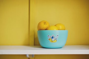 A friendly monster sticker on a blue bowl full of lemons